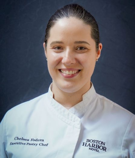 Smiling executive pastry chef portrait in a white coat, labeled Chelsea Fodera of Boston Harbor Hotel.